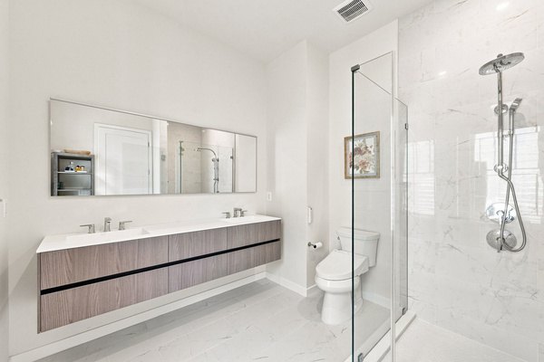 Glass-enclosed shower and luxury cabinetry